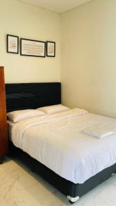 バンドンにあるNata Villa Syariah close to Telkomのベッドルーム1室(ノートパソコン付きのベッド1台付)