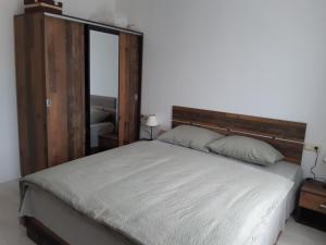 a bedroom with a large bed with a wooden headboard at Lily Beach Resort - Orhidea 402 - Sozopol in Sozopol
