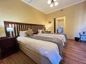 a bedroom with two beds and a lamp on a table at Tillietudlem Nature Reserve in Impendle