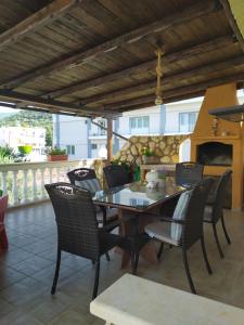 a table and chairs on a patio with a fireplace at beach house Blue Sea in Iraklitsa