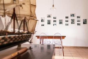 een tafel met twee stoelen en een boot aan een muur bij Admiral's apartments in Aci Catena