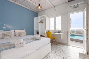 two beds in a room with a view of the ocean at Villa Ilias in Firostefani