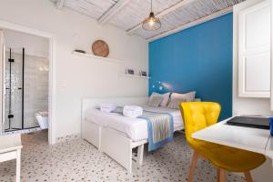 a bedroom with a blue wall and a bed and a desk at Villa Ilias in Firostefani