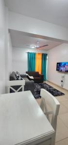 uma sala de estar com um sofá e uma televisão em Smiler's comfort em Mombasa
