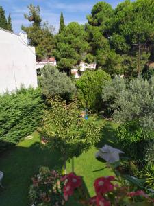 a garden with trees and bushes and flowers at beach house Blue Sea in Iraklitsa