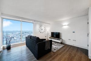 ein Wohnzimmer mit einem Sofa und einem großen Fenster in der Unterkunft Luxury Apartment With Stunning Views on 10th floor in Edgware
