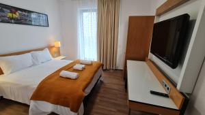 Cette chambre comprend un lit et une télévision à écran plat. dans l'établissement Jafar Resort 2, à Timişoara