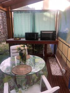 une table avec un vase de fleurs et un four micro-ondes dans l'établissement Entre ciel et mer piscine chauffée, à Saint-Leu