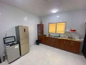 an empty kitchen with a refrigerator and a window at Loong Hostel in Riyadh