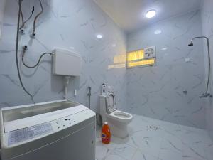 a white bathroom with a toilet and a sink at Loong Hostel in Riyadh