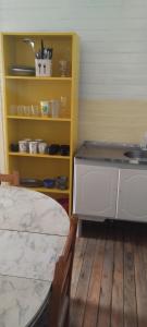 a kitchen with a table and a counter and a shelf at casas joaninha 2 in Canela