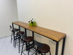 a panda bear sitting on top of a table with stools at Loong Hostel in Riyadh