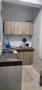 uma cozinha com um lavatório e um micro-ondas em Smiler's comfort em Mombasa
