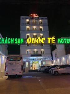 un hotel con coches aparcados delante de él por la noche en khách sạn Quốc Tế en Cà Mau