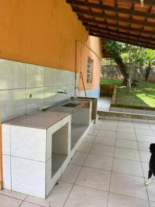 eine Küche mit einem Waschbecken und einem Hund, der in einen Innenhof geht in der Unterkunft Casa de campo com piscina em condomínio. in Ibiúna