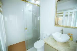 W łazience znajduje się toaleta, umywalka i prysznic. w obiekcie khách sạn Quốc Tế w mieście Cà Mau