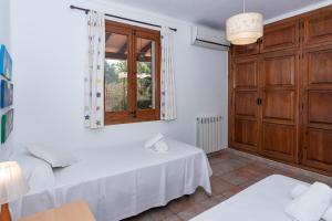 Zimmer mit einem Bett, einem Tisch und einem Fenster in der Unterkunft Villa Cuxach Mateu in Pollença