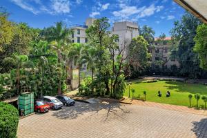 an apartment building with cars parked in a parking lot at Krushnai Resort in Lonavala