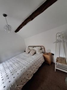 Un dormitorio con una cama blanca y una escalera en Mount Cottage, en Shrewsbury