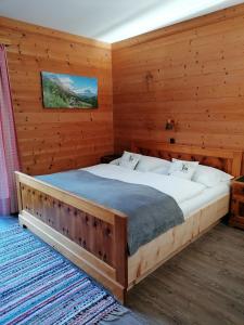 a bedroom with a large bed in a wooden room at Haus Ackerer in Leogang