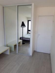 a room with a mirror and a bed and a lamp at Appartement 4 chambres à 7 min des Champs-Elysées in Nanterre