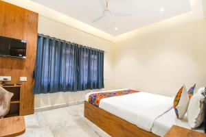 a bedroom with a bed and a tv in a room at FabHotel Prime The Golden Plaza in Tarapith