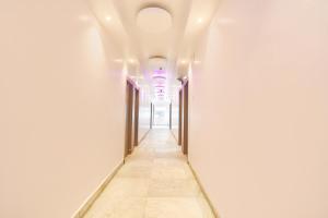a corridor in a building with white walls and a ceiling at FabHotel Prime The Golden Plaza in Tarapith