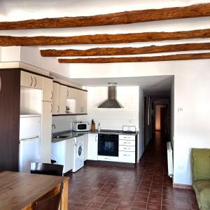 a kitchen with white appliances and a brown tile floor at Apartamentos Angelus Plaza Mayor de Graus in Graus