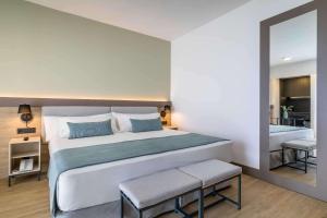 a bedroom with a large bed and a bathroom at Occidental Puerto Banús in Marbella