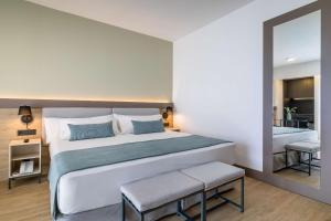 a bedroom with a large bed and a mirror at Occidental Puerto Banús in Marbella