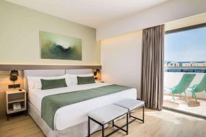 a bedroom with a large bed and a large window at Occidental Puerto Banús in Marbella