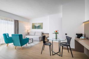 a living room with a table and chairs and a couch at Occidental Puerto Banús in Marbella