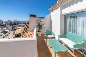 a balcony with chairs and a view of the city at Occidental Puerto Banús in Marbella