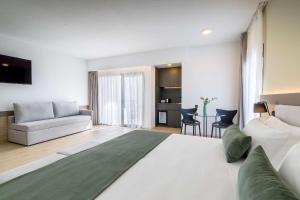 a bedroom with a large bed and a living room at Occidental Puerto Banús in Marbella