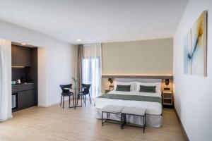 a hotel room with a bed and a table and chairs at Occidental Puerto Banús in Marbella