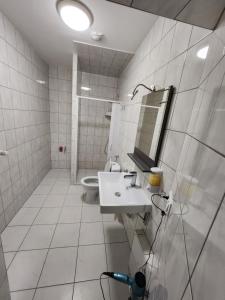 a white bathroom with a sink and a toilet at Pension Seevetal in Seevetal