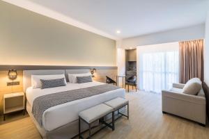 a bedroom with a large bed and a couch at Occidental Puerto Banús in Marbella
