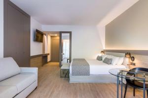 a hotel room with a bed and a couch at Occidental Puerto Banús in Marbella
