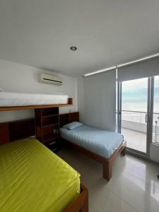 um quarto com 2 camas e vista para o oceano em Acogedor Departamento Vacacional em Atacames