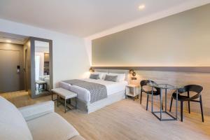 a bedroom with a bed and a table and chairs at Occidental Puerto Banús in Marbella