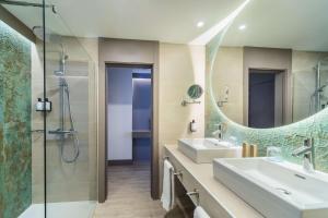 a bathroom with a sink and a shower and a mirror at Occidental Puerto Banús in Marbella