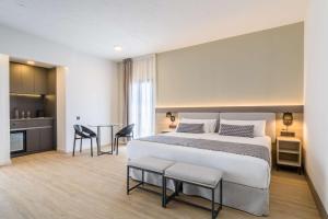a bedroom with a large bed and a kitchen at Occidental Puerto Banús in Marbella