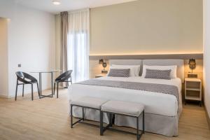 a bedroom with a bed and a table and chairs at Occidental Puerto Banús in Marbella