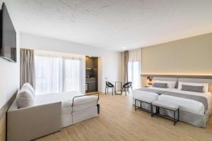 a hotel room with two beds and a couch at Occidental Puerto Banús in Marbella