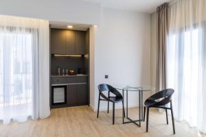 a kitchen with a glass table and two chairs at Occidental Puerto Banús in Marbella