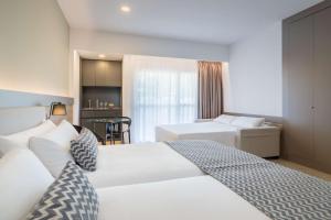 a hotel room with two beds and a table at Occidental Puerto Banús in Marbella