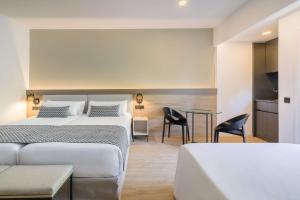 a hotel room with two beds and a table at Occidental Puerto Banús in Marbella