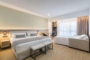 a large bedroom with two beds and a couch at Occidental Puerto Banús in Marbella