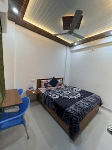 a bedroom with a bed and a ceiling fan at Goroomgo YP Stays Dehradun - Parking facilities - Best Seller in Dehradun