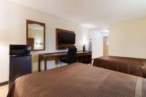 une chambre d'hôtel avec 2 lits et un bureau dans l'établissement Rodeway Inn, à Gallup